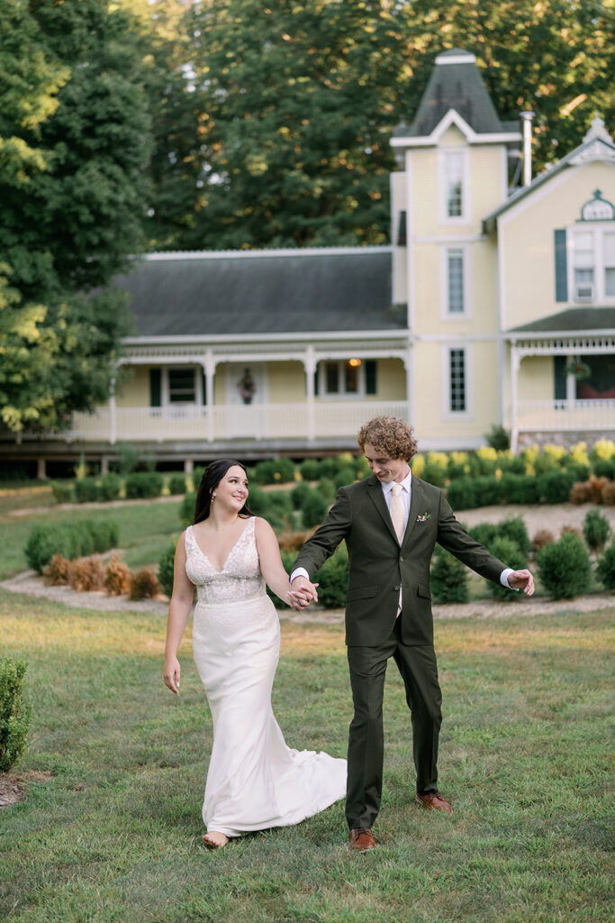 Couple walking the grounds at Stonegate Manor with historic estate building in the background
