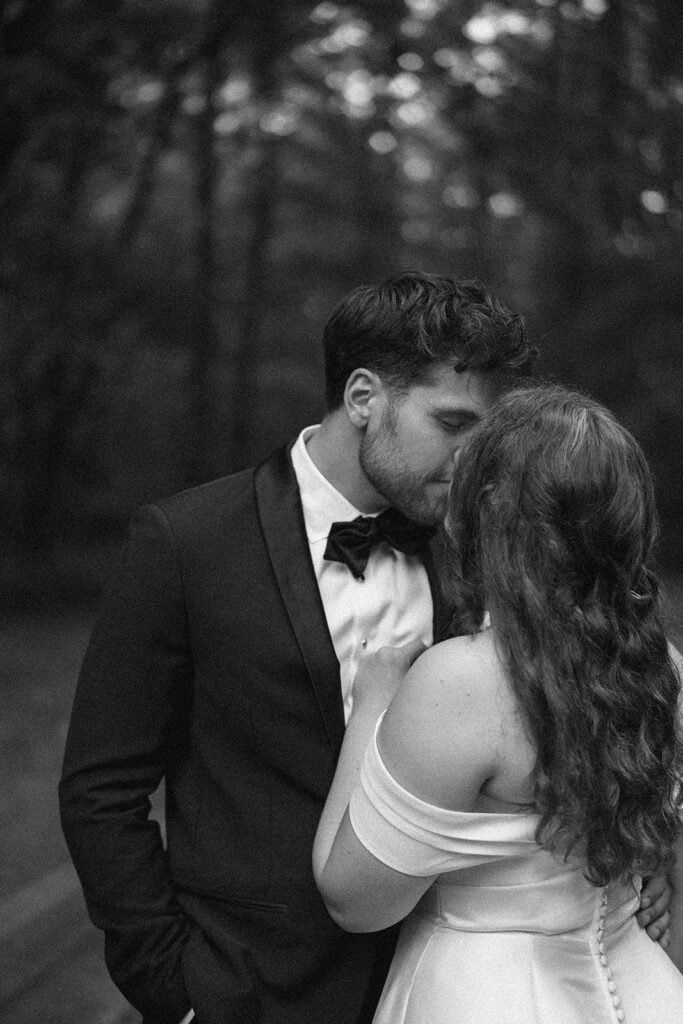 Black and white wedding portrait of bride and groom sharing a quiet moment in the woods of Southwest Michigan.