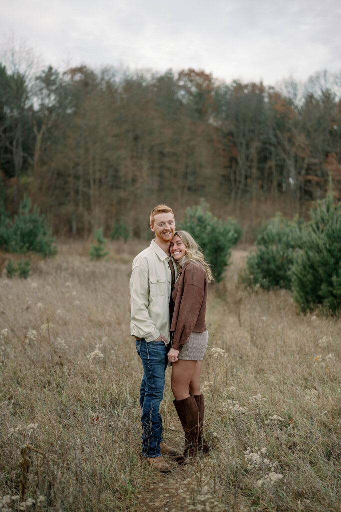 Portrait of engaged couple standing in open field during fall session in Michigan, earthy and warm tones