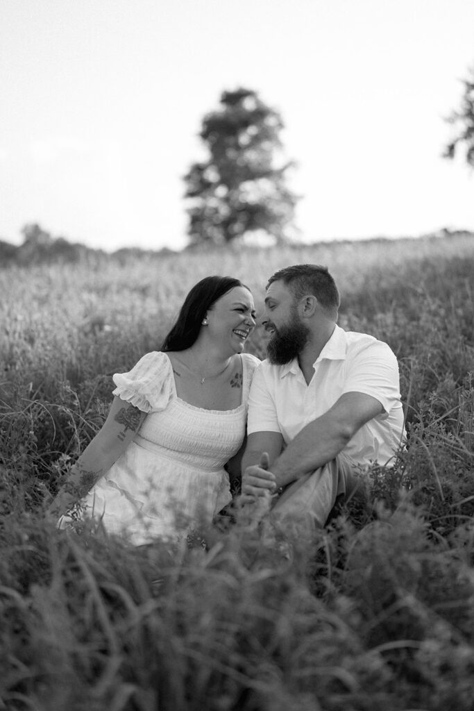 Romantic engagement photo of couple standing in a tall grassy field in Michigan
