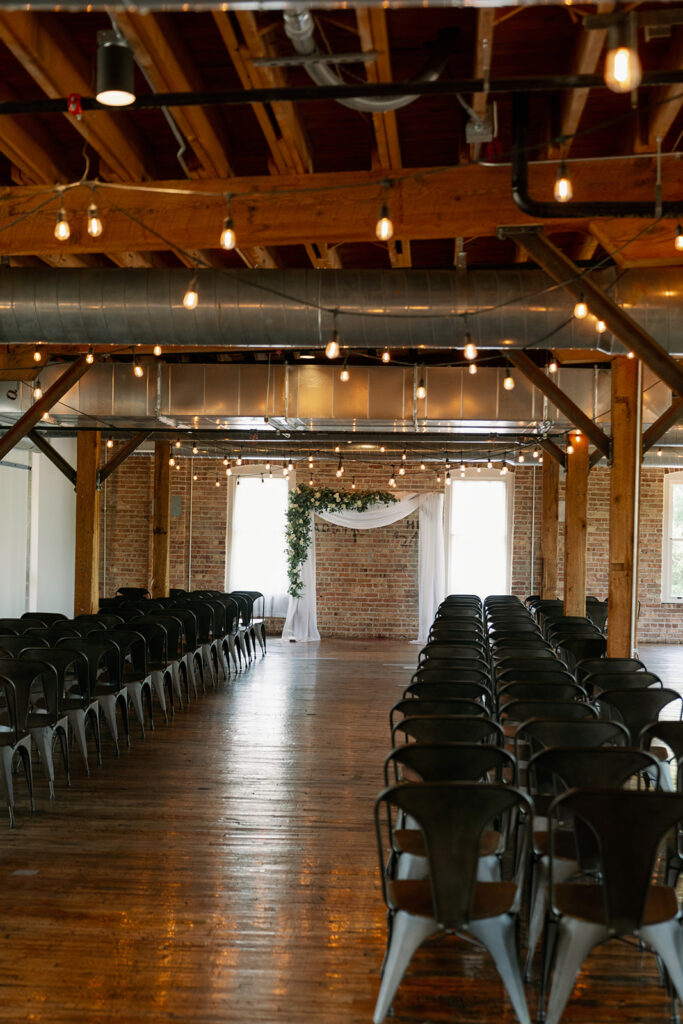 Indoor ceremony setup inside Record Box Loft with wooden beams and romantic string lighting