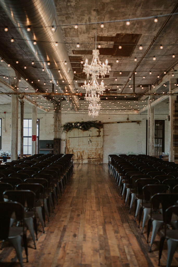 Indoor ceremony at Journeyman Distillery with wooden floors and warm industrial lighting