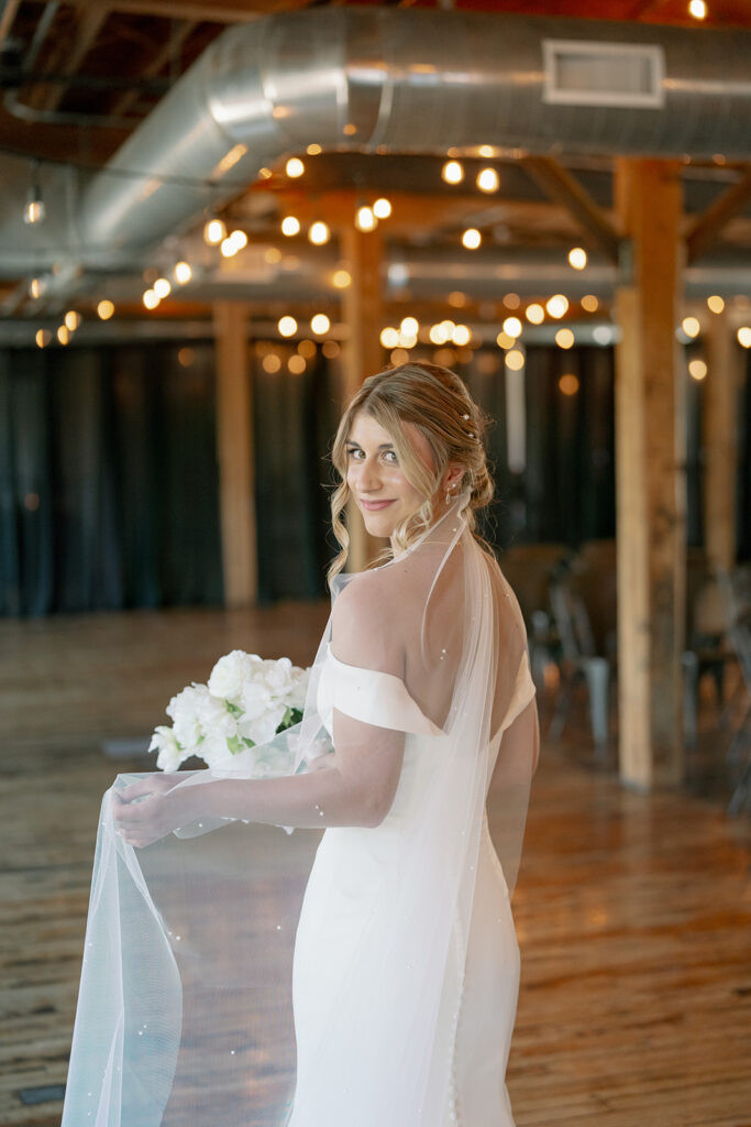 Bride posing inside Record Box Loft with warm natural light and exposed brick interior