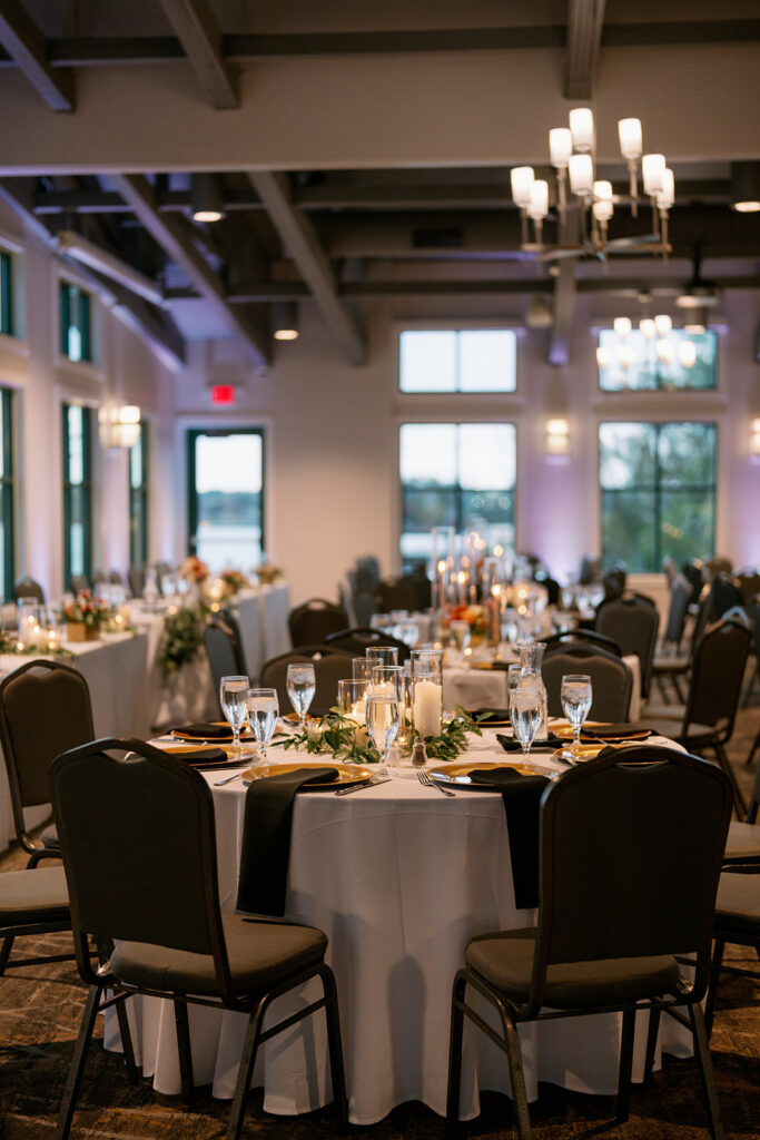 Wedding reception inside Boatwerks Waterfront ballroom with warm lighting and round tables set for an elegant Michigan celebration