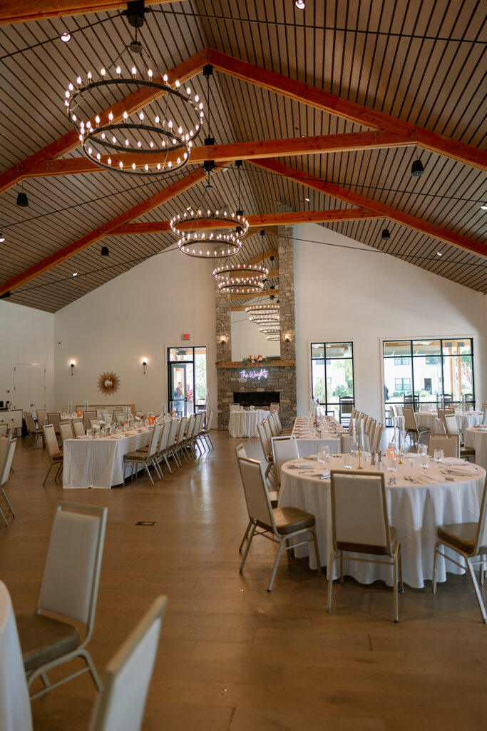 Indoor reception room at Baypointe Woods with chandeliers and modern warm wood architecture