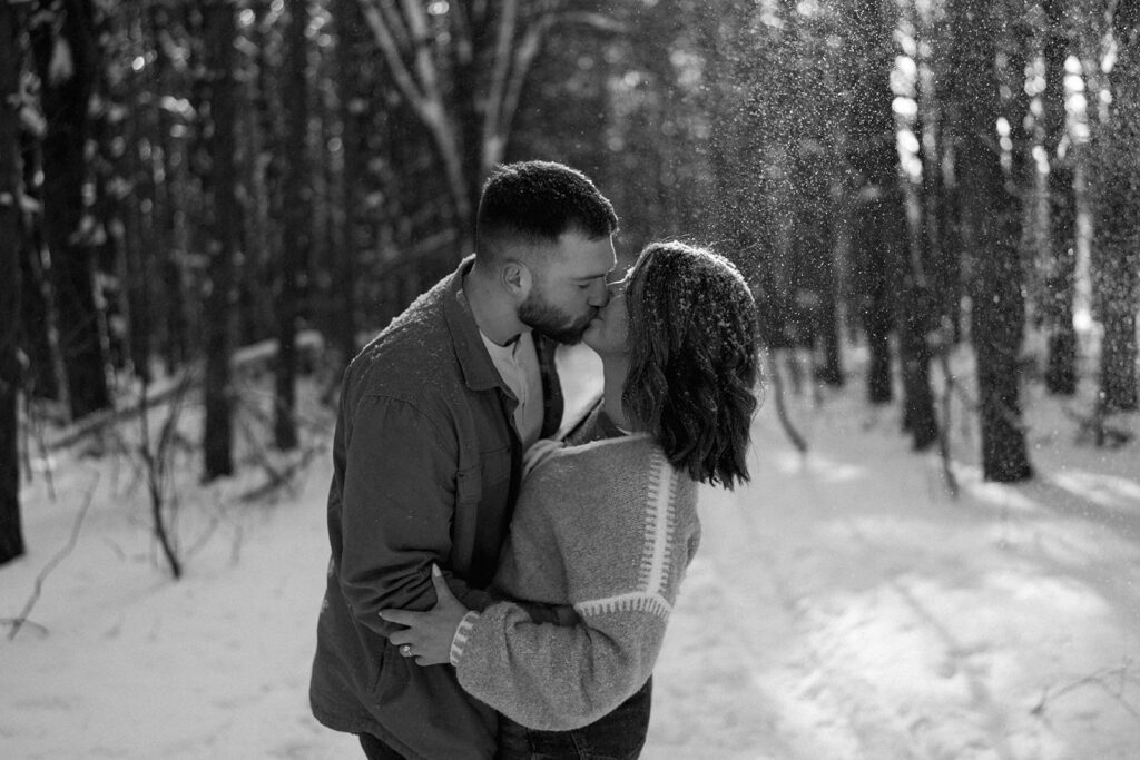 Black and white portrait of a couple kissing during a winter engagement session in Kalamazoo Michigan