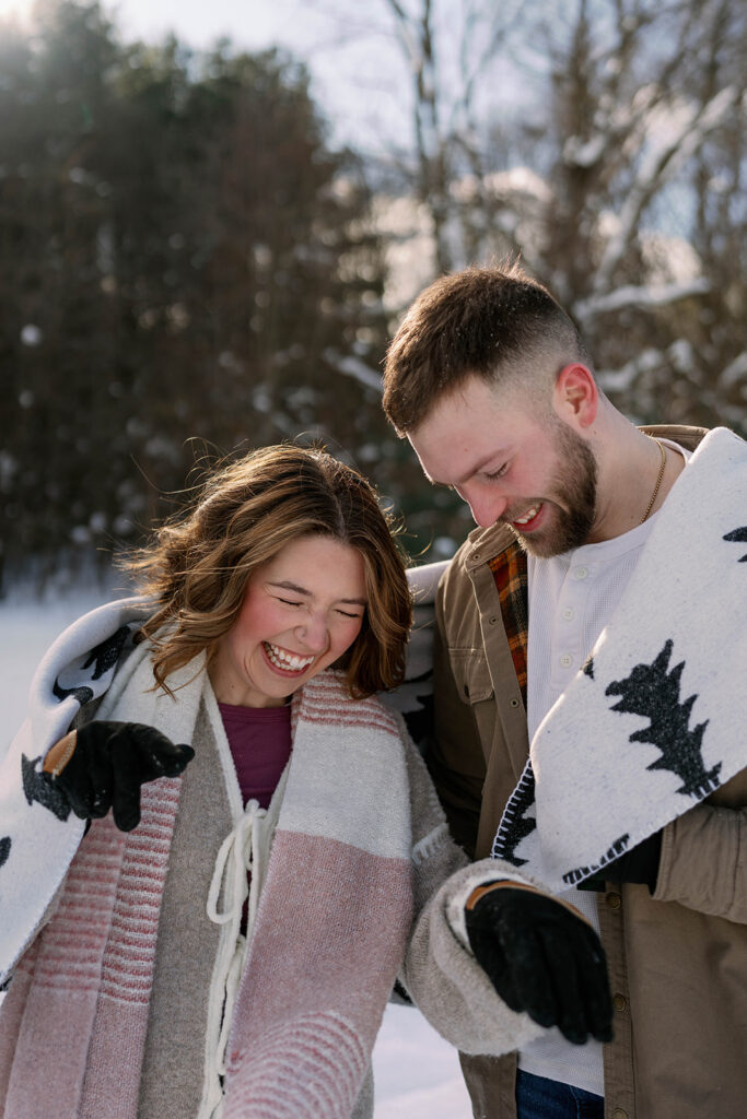Cozy winter portrait of a couple smiling together outdoors in Southwest Michigan