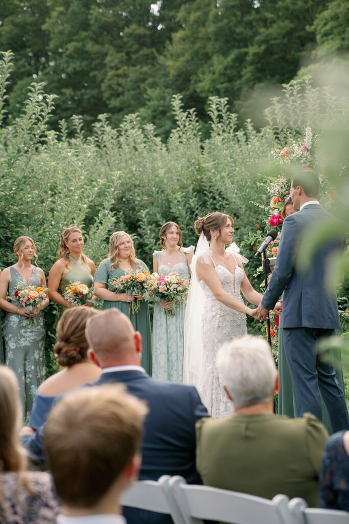 bride and groom exchanging vows in apple orchard ceremony in Michigan