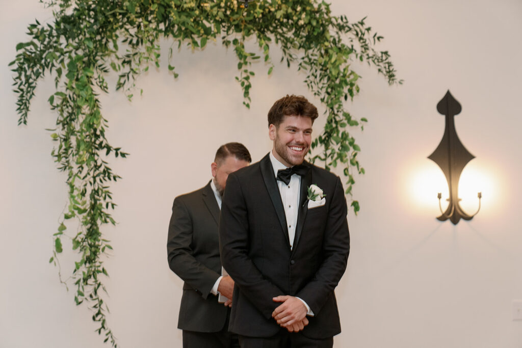 Groom smiling at altar