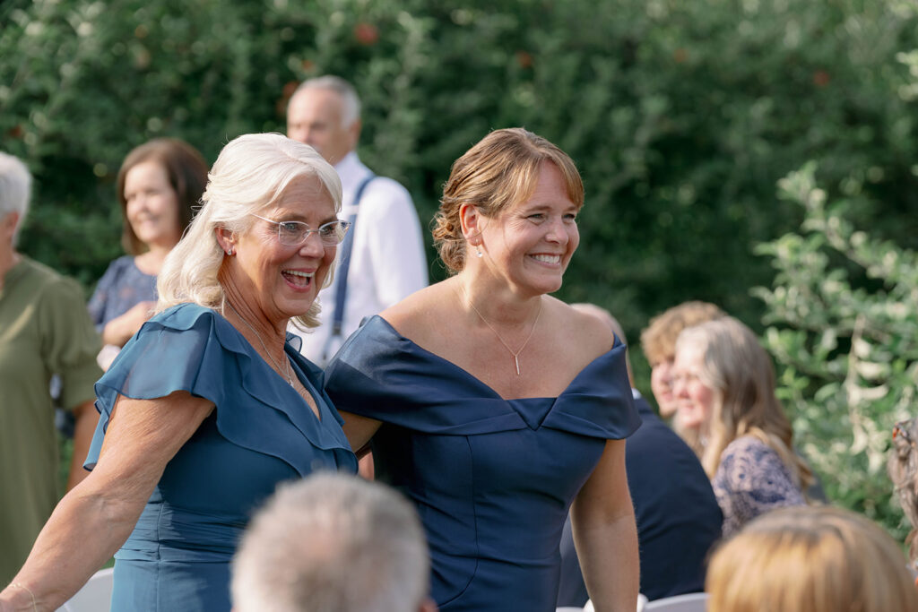 mothers of the bride and groom walking down the aisle at Nugent Orchards wedding in Frankfort Michigan