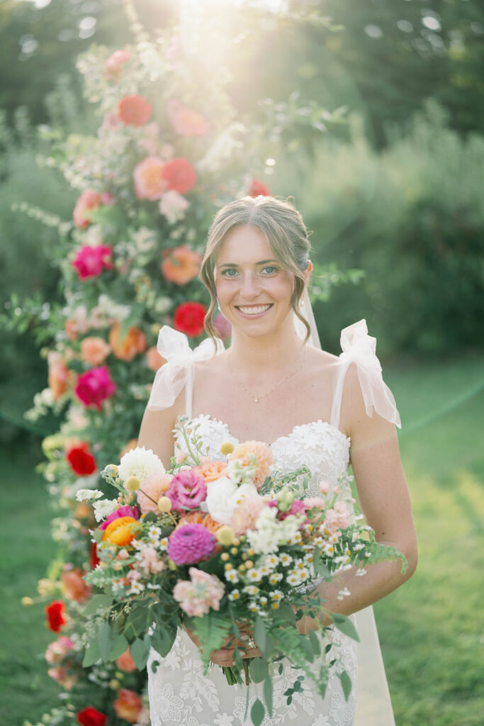bride smiling with colorful summer wedding bouquet at Nugent Orchards wedding in Michigan