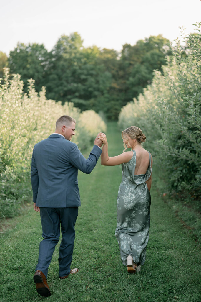wedding guests walking through the orchard at Nugent Orchards wedding in Frankfort Michigan