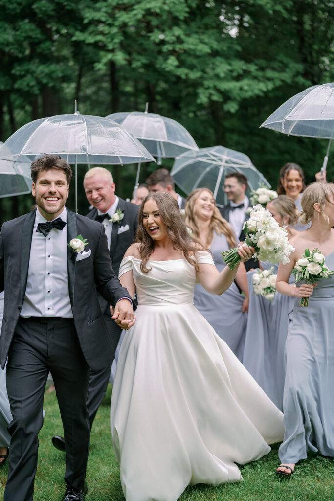 wedding party walking together with umbrellas Morris Estate Michigan