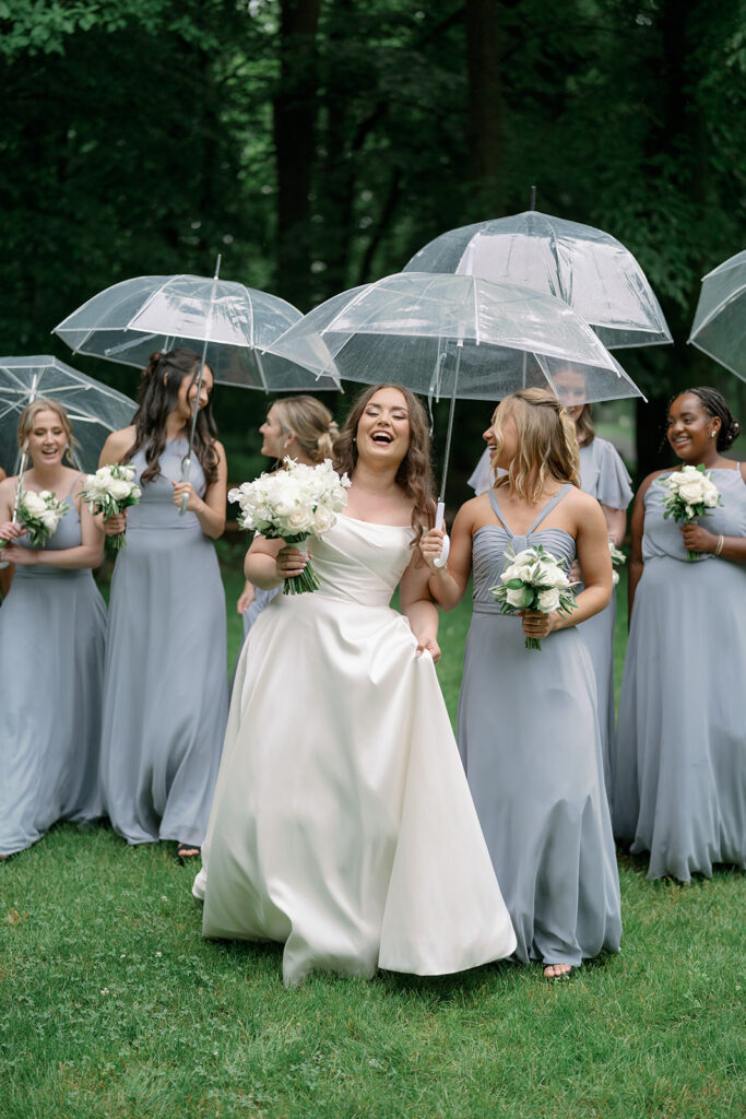 bride and bridesmaids walking with umbrellas rainy wedding Michigan