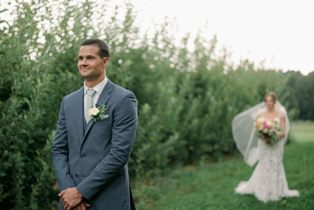 groom facing away before first look at Nugent Orchards wedding in Frankfort Michigan