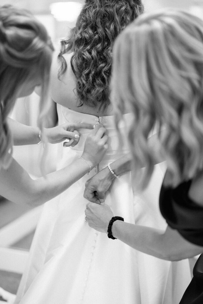 mother and sister helping bride into her dress at the Morris Estate Venue