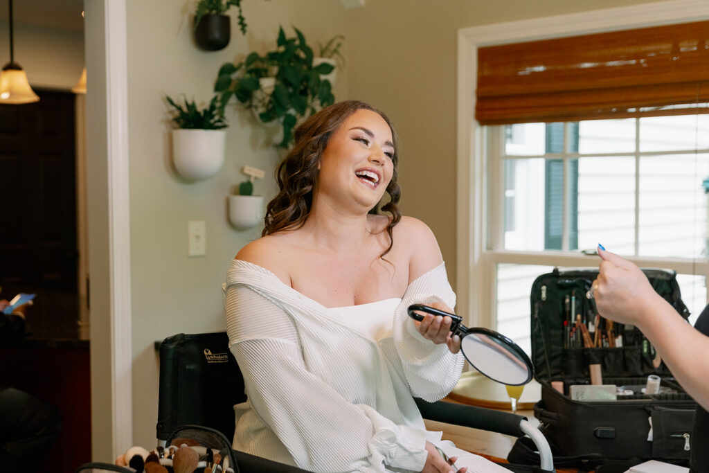 Bride laughing while having her makeup done