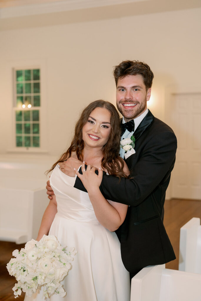 bride and groom smiling together inside morris estate chapel