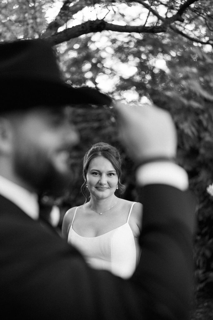 black and white portrait of bride framed through groom during Cafe Cortina wedding in Dearborn Michigan
