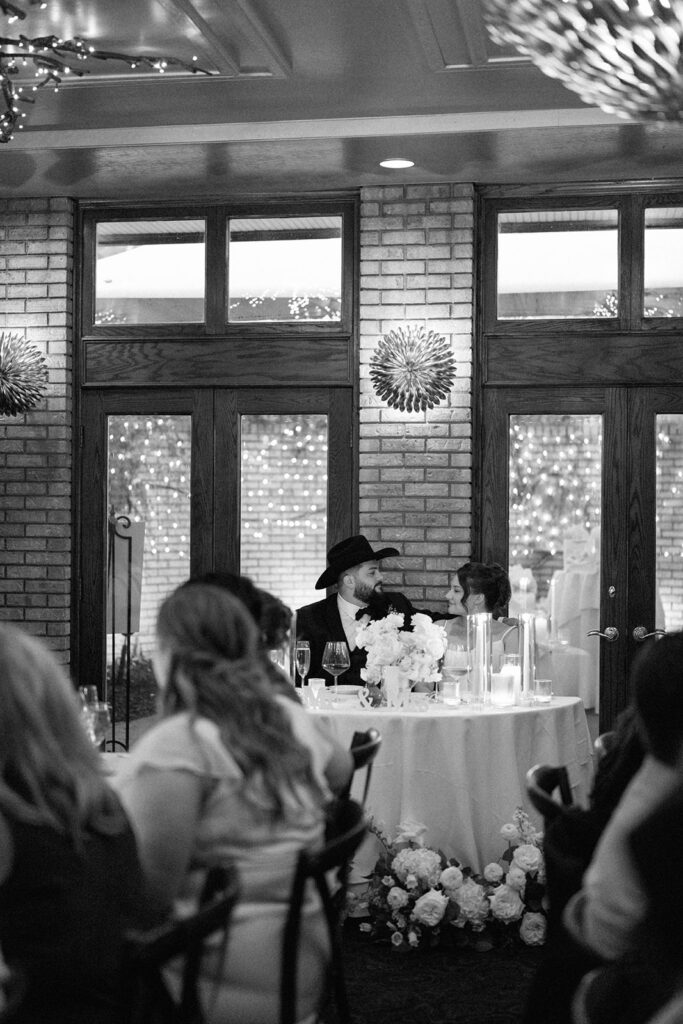bride and groom seated at head table during reception at Cafe Cortina in Dearborn Michigan