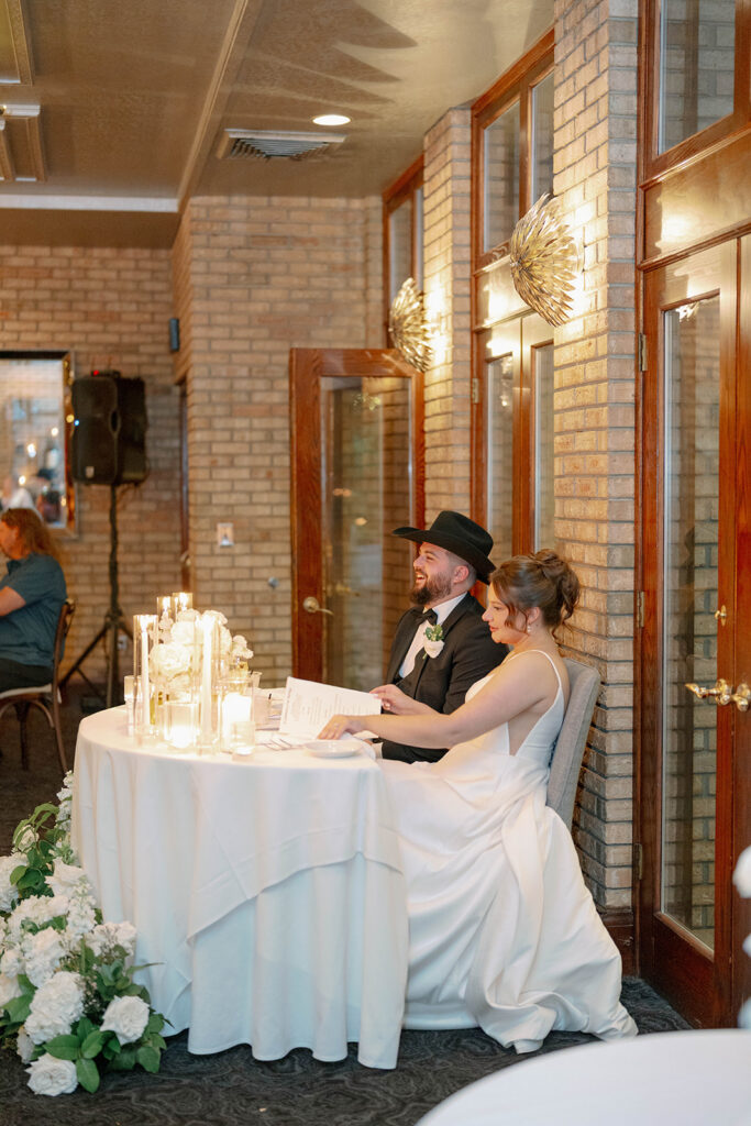 bride and groom listening to speeches at reception head table at Cafe Cortina in Dearborn Michigan