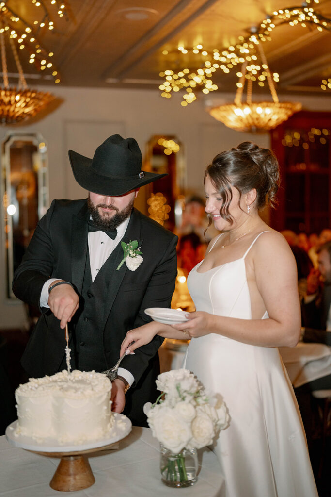 bride and groom cutting wedding cake during reception at Cafe Cortina in Dearborn Michigan