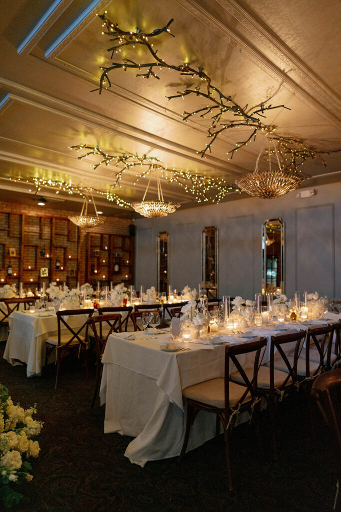 wide view of Cafe Cortina wedding reception with candlelit tables and twinkle lights in Dearborn Michigan