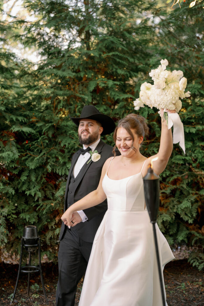bride holding bouquet up while walking with groom during romantic Cafe Cortina wedding in Dearborn Michigan