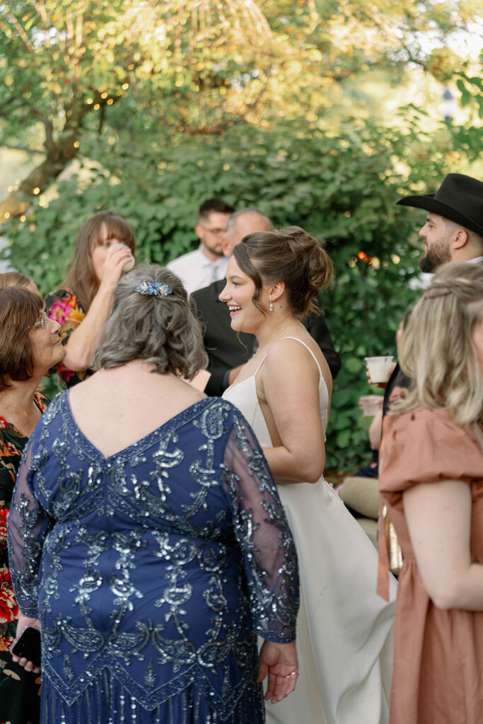 bride laughing with guests during cocktail hour at Cafe Cortina wedding in Dearborn Michigan